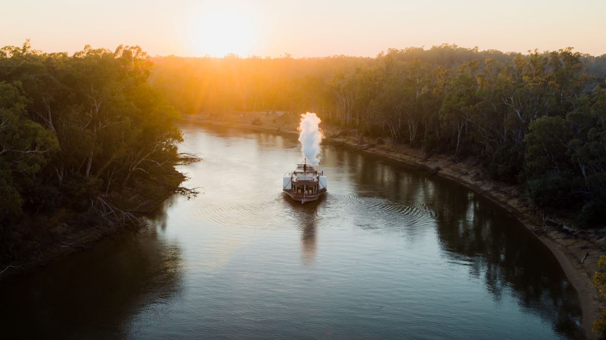 Steam boat on river at sunset